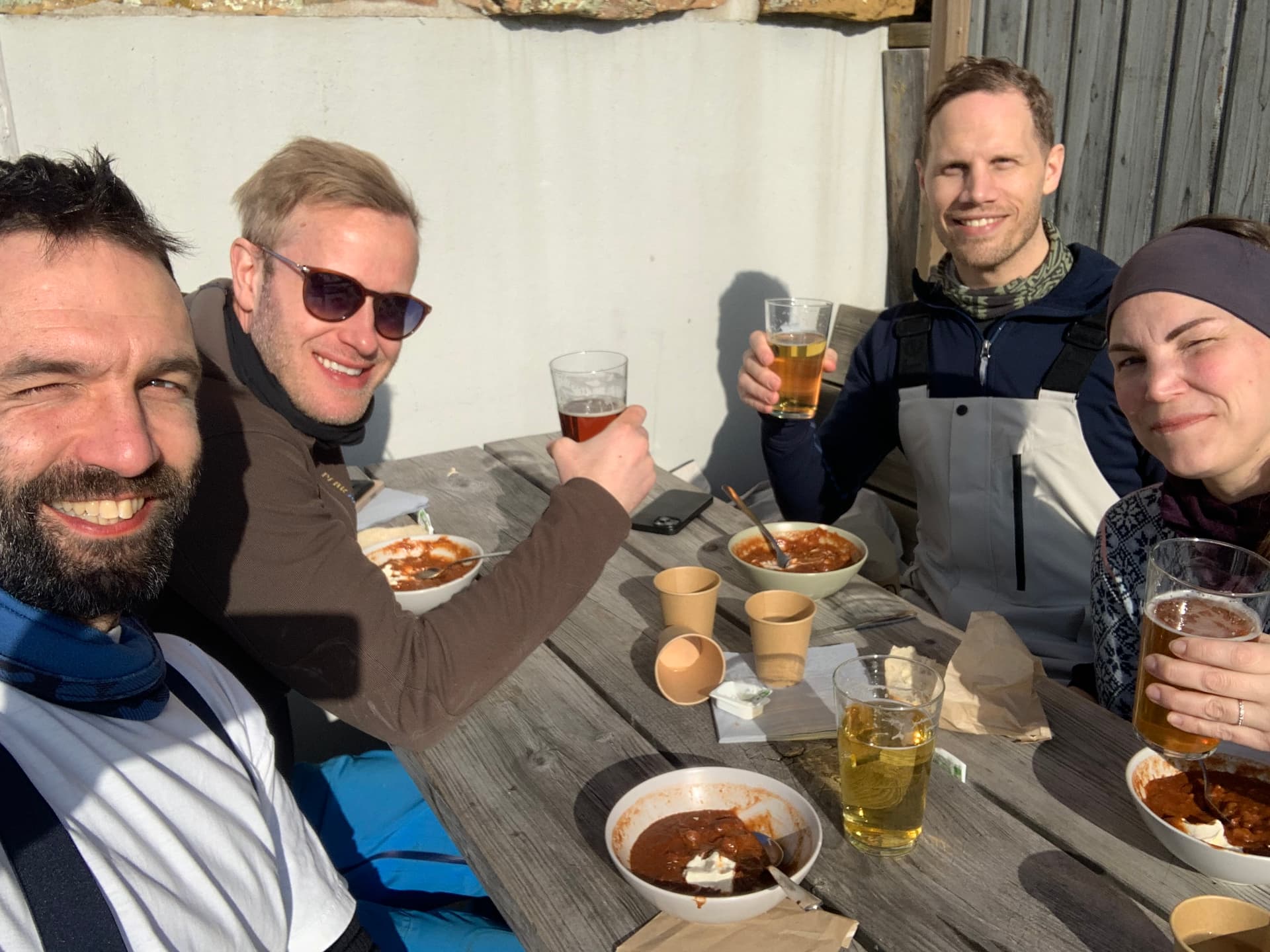 Fyra kollegor skålar tillsammans under en skidresa